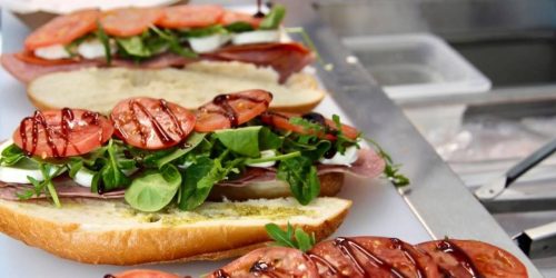 Caprese sandwiches getting dressed up with balsamic glaze at The SandWitch Truck! Fresh mozzarella, tomato, and greens on crusty bread, ready for a beach picnic.